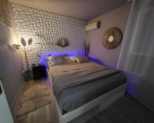 - une chambre dotée d'un lit avec des lumières violettes dans l'établissement Petit paradis du 66,Canet Roussillon, à Canet