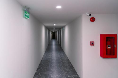 a long hallway with a red box on the wall at วัน บัดเจท เชียงราย บ้านใหม่ in Chiang Rai