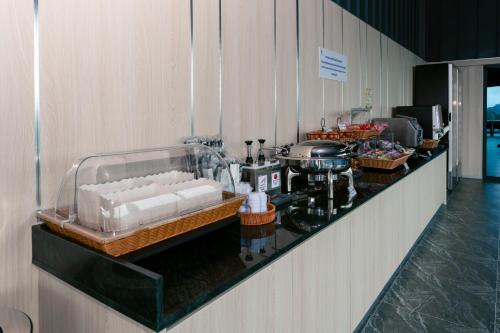 a kitchen with a counter with a buffet of food at วัน บัดเจท เชียงราย บ้านใหม่ in Chiang Rai
