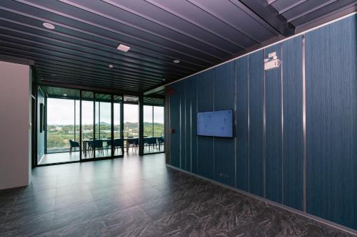 an empty room with blue walls and a flat screen tv at วัน บัดเจท เชียงราย บ้านใหม่ in Chiang Rai