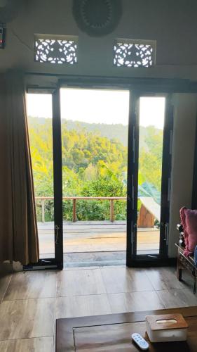 a living room with doors open to a balcony at Munduk Nature Lodge in Munduk
