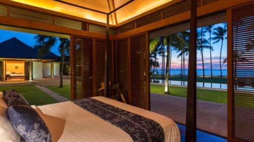 a bedroom with a bed and a view of the ocean at Jivana Beach Villas in Natai Beach