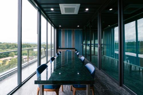 a conference room with a green table and chairs at วัน บัดเจท เชียงราย บ้านใหม่ in Chiang Rai