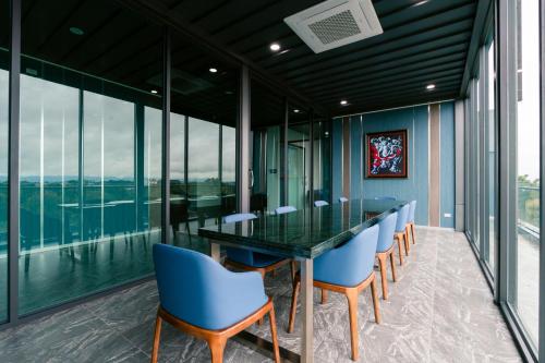 a dining room with a glass table and blue chairs at วัน บัดเจท เชียงราย บ้านใหม่ in Chiang Rai
