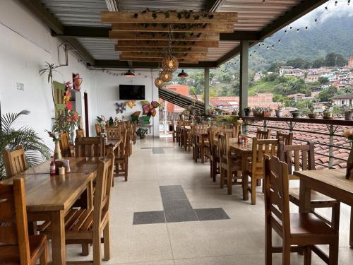 a restaurant with wooden tables and chairs and a balcony at Hotel Balcon Tamesino in Támesis