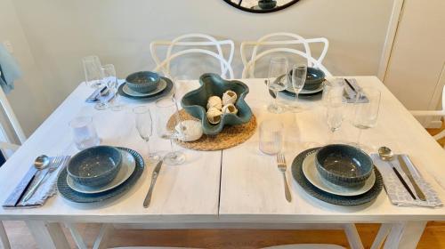 a white table with plates and dishes on it at A Sunday Kind of Stay - 4 Bedroom 2 Bathroom Holiday Home Near Manly, Shops in Capalaba