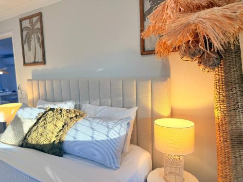 a bedroom with a bed with a pillow and a lamp at A Sunday Kind of Stay - 4 Bedroom 2 Bathroom Holiday Home Near Manly, Shops in Capalaba