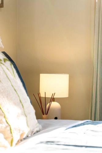 a bedroom with a bed with a lamp on it at A Sunday Kind of Stay - 4 Bedroom 2 Bathroom Holiday Home Near Manly, Shops in Capalaba