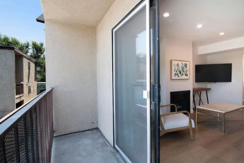 a balcony with a sliding glass door with a chair at Stylish 1BR Near Universal Studios with Parking in Los Angeles