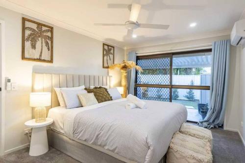 a bedroom with a large bed and a window at A Sunday Kind of Stay - 4 Bedroom 2 Bathroom Holiday Home Near Manly, Shops in Capalaba