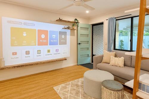 a living room with a large screen in a room at A Sunday Kind of Stay - 4 Bedroom 2 Bathroom Holiday Home Near Manly, Shops in Capalaba