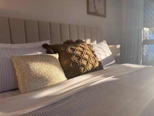 a bed with two pillows on top of it at A Sunday Kind of Stay - 4 Bedroom 2 Bathroom Holiday Home Near Manly, Shops in Capalaba