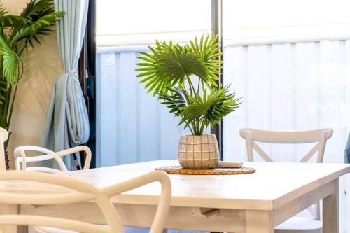a dining room table with a potted plant on it at A Sunday Kind of Stay - 4 Bedroom 2 Bathroom Holiday Home Near Manly, Shops in Capalaba