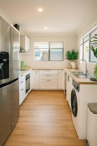a kitchen with a sink and a dishwasher at A Sunday Kind of Stay - 4 Bedroom 2 Bathroom Holiday Home Near Manly, Shops in Capalaba