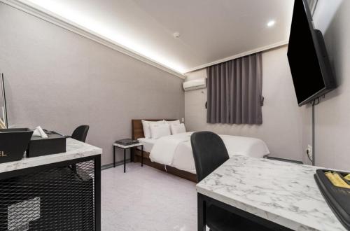 プチョンにあるMomo Hotelのベッドとテレビがあるホテルの部屋