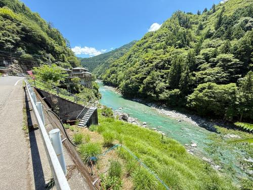 a river next to a road next to a mountain at 一棟貸切-Stay ISHIWAKI in Miyoshi