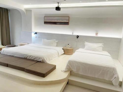 two beds in a room with white walls at Sky Garden Inn in Guilin
