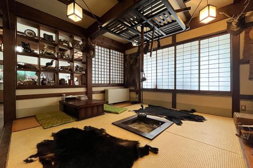 Una habitación grande con una vaca grande tendida en el suelo. en 湯の花ふわり 湯元館, en Hirayu