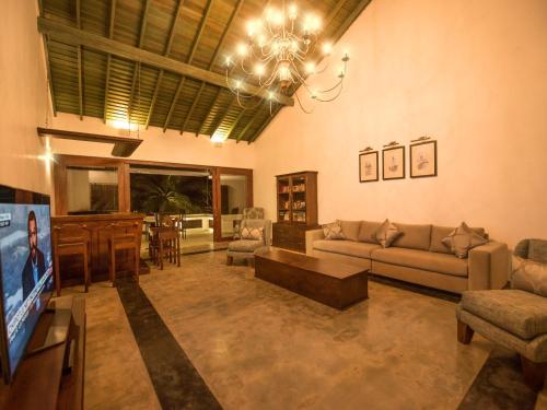 a living room with a couch and a flat screen tv at Villa 46 in Hikkaduwa