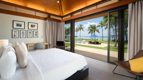 a bedroom with a bed and a view of the ocean at Jivana Beach Villas in Natai Beach