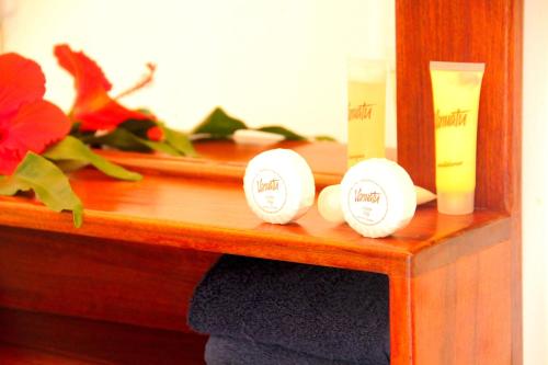 a wooden shelf with two candles and some flowers at Moorings Hotel in Port Vila