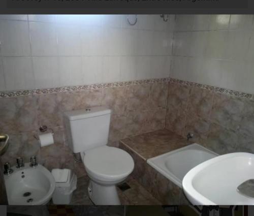 a bathroom with a toilet and a tub and a sink at Hotel Carboni in Larroque