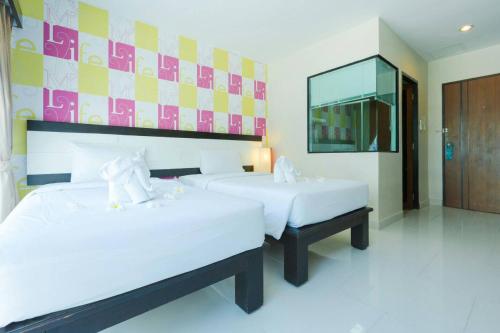 a bedroom with two beds and a mirror at Neo Hotel in Jomtien Beach
