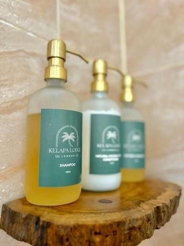 two bottles of soap sitting on top of a log at Kelapa Lodge - Lombok - in Senggigi 