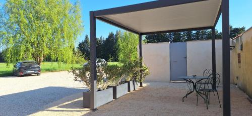 a pavilion with a table and chairs and a car at Gîte Mas de la Restanque in Monteux