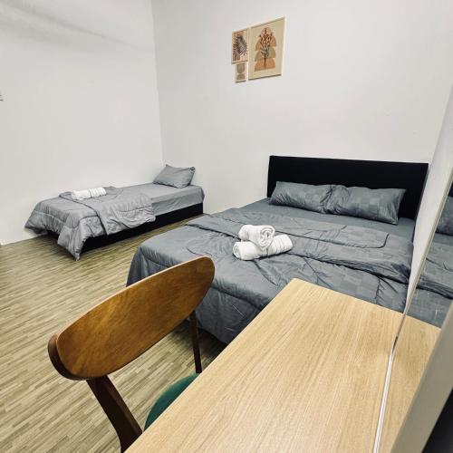 a bedroom with a bed and a table with a chair at Hey Rest Up with shared bathroom in Ipoh