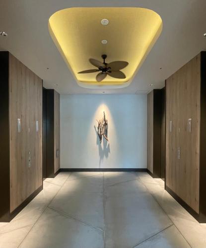 a room with a ceiling fan and a painting on the wall at THE NEST NAHA in Naha