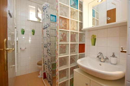 a bathroom with a sink and a shower at Főnix Apartmanház in Hajdúszoboszló