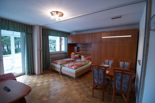 ヴィンターベルクにあるFeWo-Winterbergのベッド、テーブル、椅子が備わる客室です。