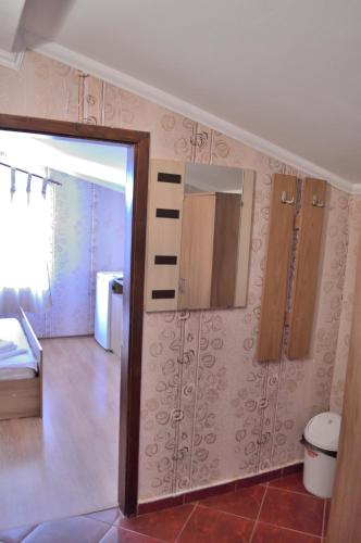 ein Zimmer mit einer Tür und ein Schlafzimmer mit einem Bett in der Unterkunft Hotel Kibor in Gŭlŭbovo