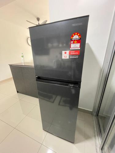 un réfrigérateur avec un autocollant sur le devant dans l'établissement Acacia Residences KLIA by Wanfik Homesta, à Sepang