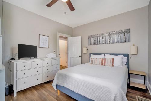 a bedroom with a white bed and a tv at Cozy Cottage in the Heart of Hyde Park home in Cincinnati