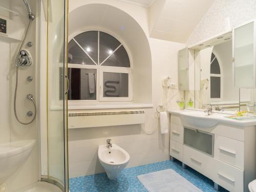 a bathroom with a shower and a sink and a toilet at Hotel Uyut in Surgut