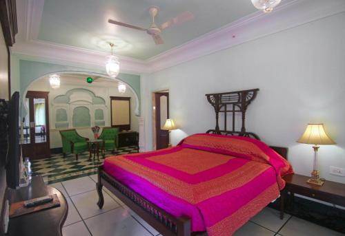 a bedroom with a bed and a living room at Shahpura House in Jaipur