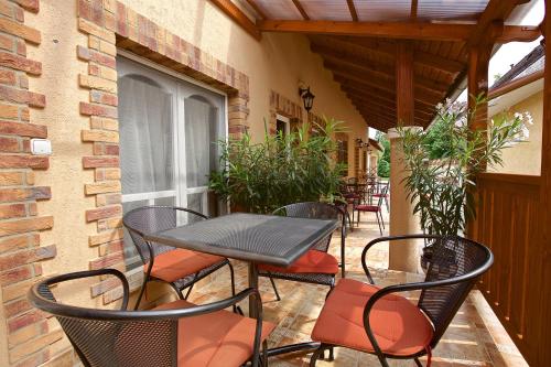 een patio met een tafel en stoelen op een balkon bij Főnix Apartmanház in Hajdúszoboszló