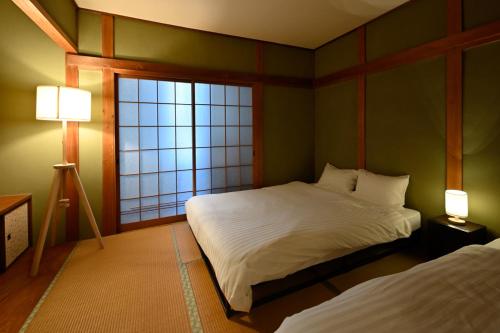 名古屋市にあるCastle Land NAGOYA Family Friendly 5min from Stationのベッド2台と窓のある寝室