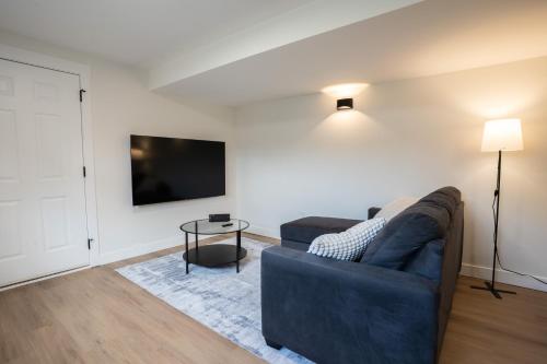 a living room with a couch and a tv at Peaceful Suite near Vernon Armstrong Brand New in Armstrong