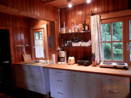eine Küche mit einer Theke, einem Waschbecken und einem Fenster in der Unterkunft Schalale in Kanzelhöhe