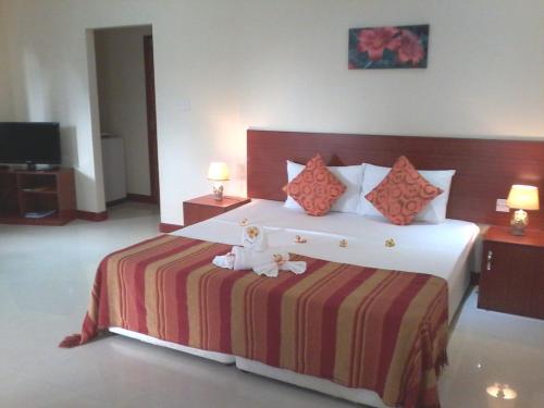 a bedroom with a bed with two stuffed animals on it at Precious Residence C in Grand'Anse
