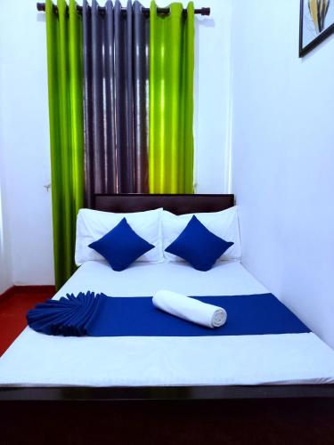 a bedroom with a bed with blue and green curtains at Green Villa in Nuwara Eliya