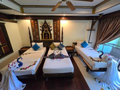 two beds in a room with flowers on them at Le Ayodhaya Palace Krabi Beach Resort in Krabi town