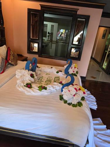 a bed with two stuffed animals on top of it at Le Ayodhaya Palace Krabi Beach Resort in Krabi town