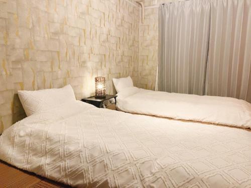 a bedroom with two beds and a table with a lamp at seto sea in Takamatsu