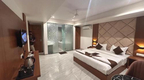 a bedroom with a bed and a tv in a room at Hotel Sterling Executive in Navi Mumbai