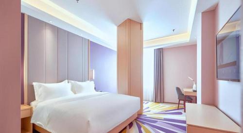 a hotel room with a white bed and a desk at Lavande Hotel Changchun Gaoxin Jilin University in Changchun