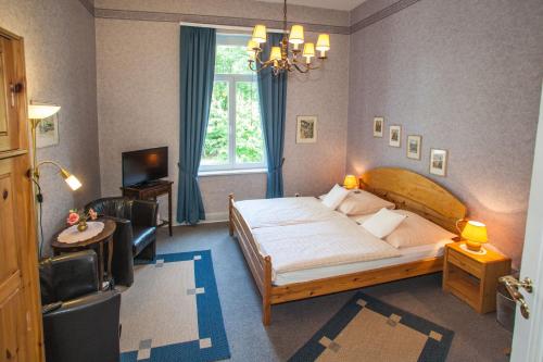a bedroom with a large bed and a large window at Hotel Rosenau in Bad Harzburg